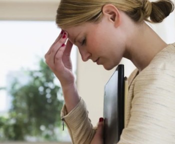 Vrouw met blond haar en beige shirt maakt zich zorgen over de verwardheid door stress oorzaak.