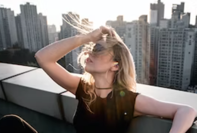 Vrouw met blond los haar op dak van flat vraagt zich af wat is verwardheid door stress.